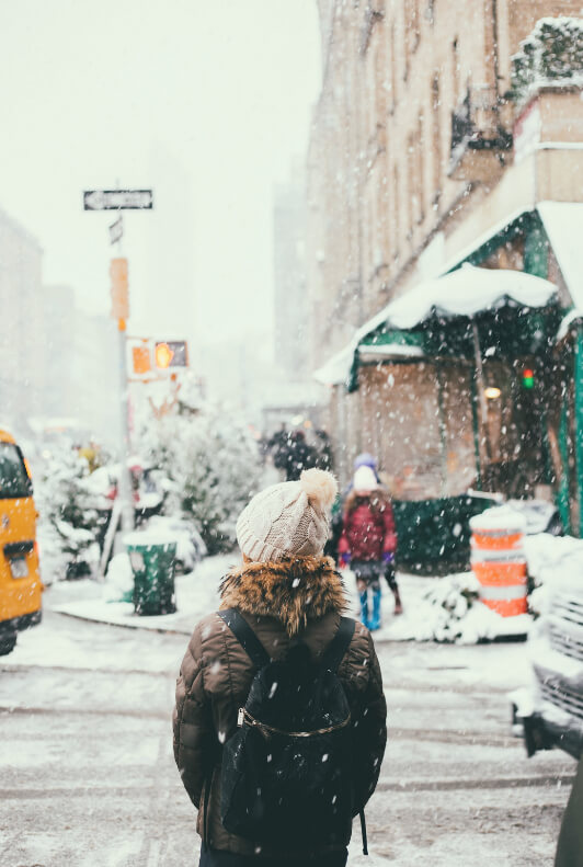 mujer bajo la nieve en una ciudad