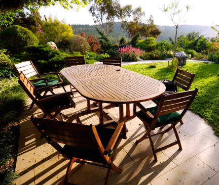 Mesa grande de jardín de madera color marrón oscuro con siete sillas alrededor
