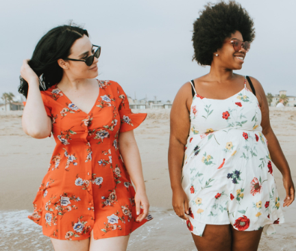 Dos mujeres paseando por la playa con vestidos veraniegos