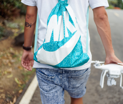 Hombre de espaldas con mochila saco Nike azul y blanca