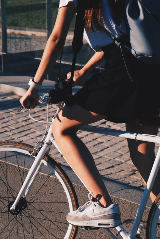 Mujer en bicicleta con zapatillas nike